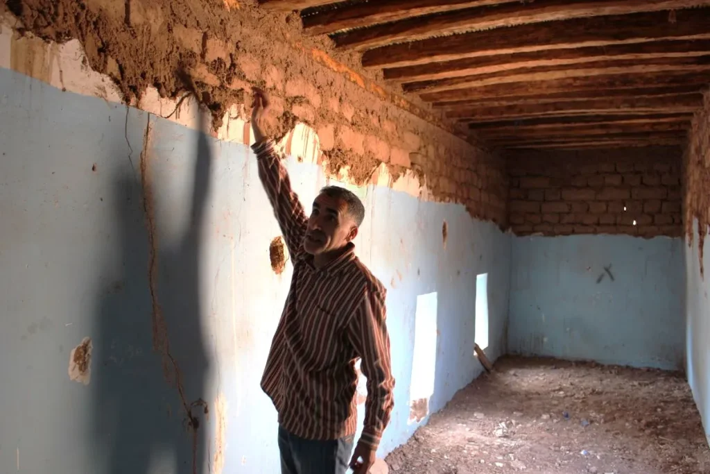 Mohamed Boussalh, director of CERKAS, standing in front of a wall under construction in the kasbah of Taourirte, Ouarzazate, May 2014. Photo: sudestmaroc.com